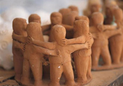 Clay figures of people standing in a circle